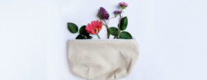 A makeup bag with flowers growing from it.